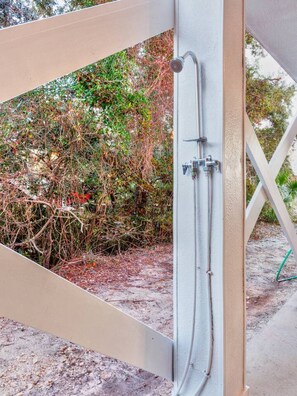 A shower enclosure with a metal frame, a showerhead, and a control valve. - Flip Oasis Lockout · Coastal Comfort: Hot Tub, Foosball & Arcade (Gulf Shores)