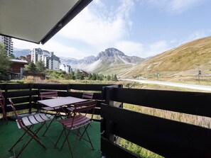 An outdoor seating area with a view of mountains and a road. - Modern cross-through apartment - 4-5 guests (Tignes-Val Claret)