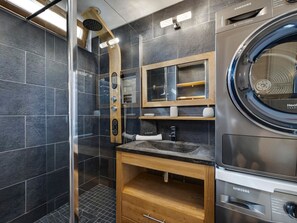 A modern bathroom with a built-in shower, a Samsung washing machine, and a wooden vanity. - Modern cross-through apartment - 4-5 guests (Tignes-Val Claret)
