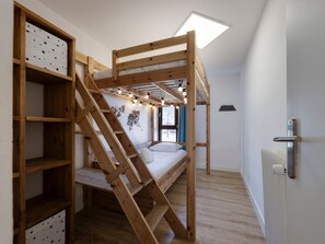 A bunk bed with a wooden ladder, a shelf unit with star patterns, and a skylight above. - Modern cross-through apartment - 4-5 guests (Tignes-Val Claret)