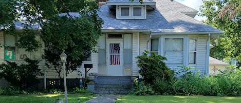 A residential house with a front yard, steps leading to the entrance, and a mailbox.