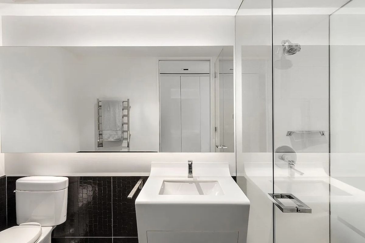 Ein modernes Badezimmer mit Toilette, Waschbecken und Duschbereich.