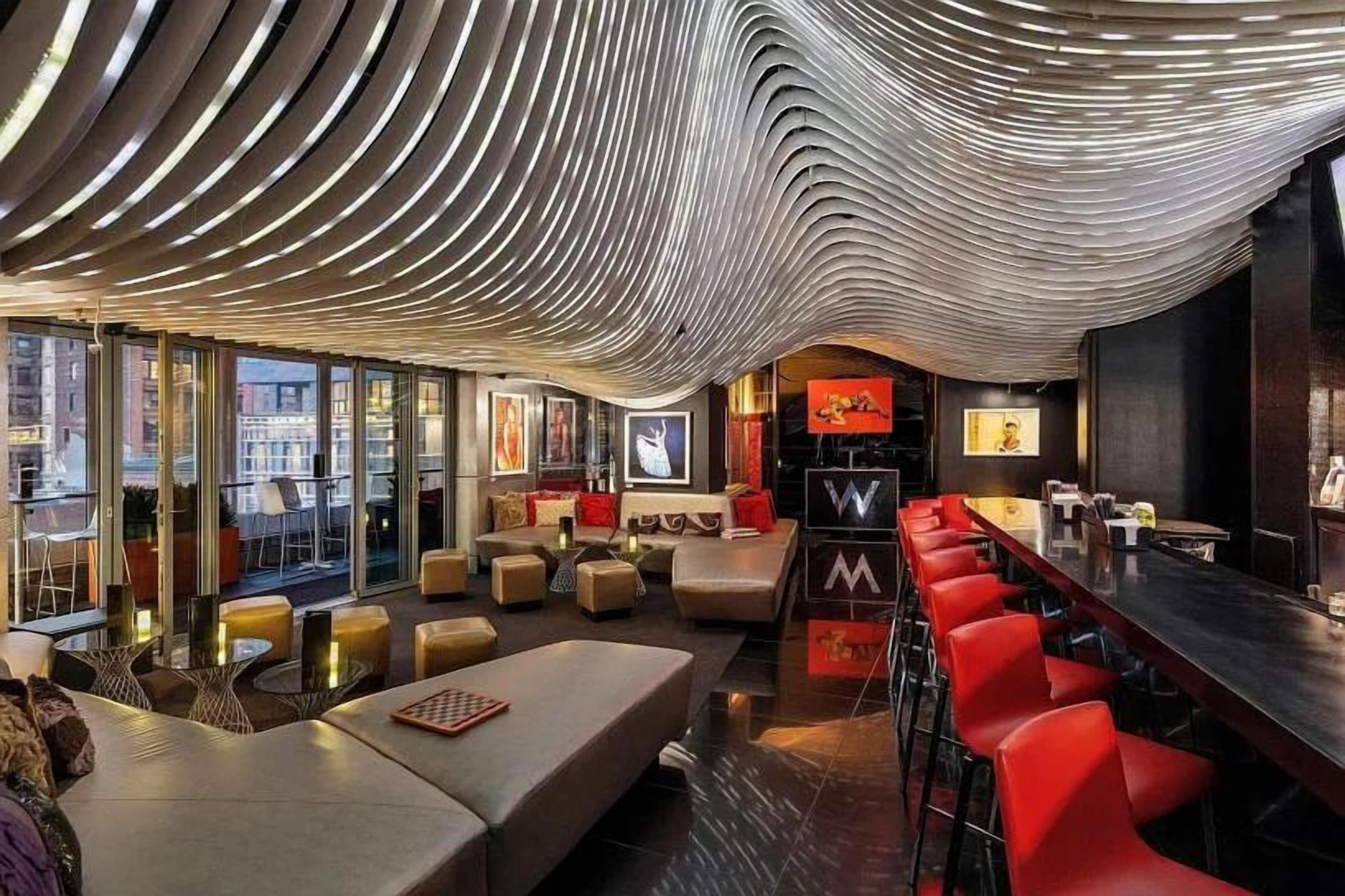 Ein modernes Interieur mit gewölbter Decke, Sitzbereichen und einer Bar.