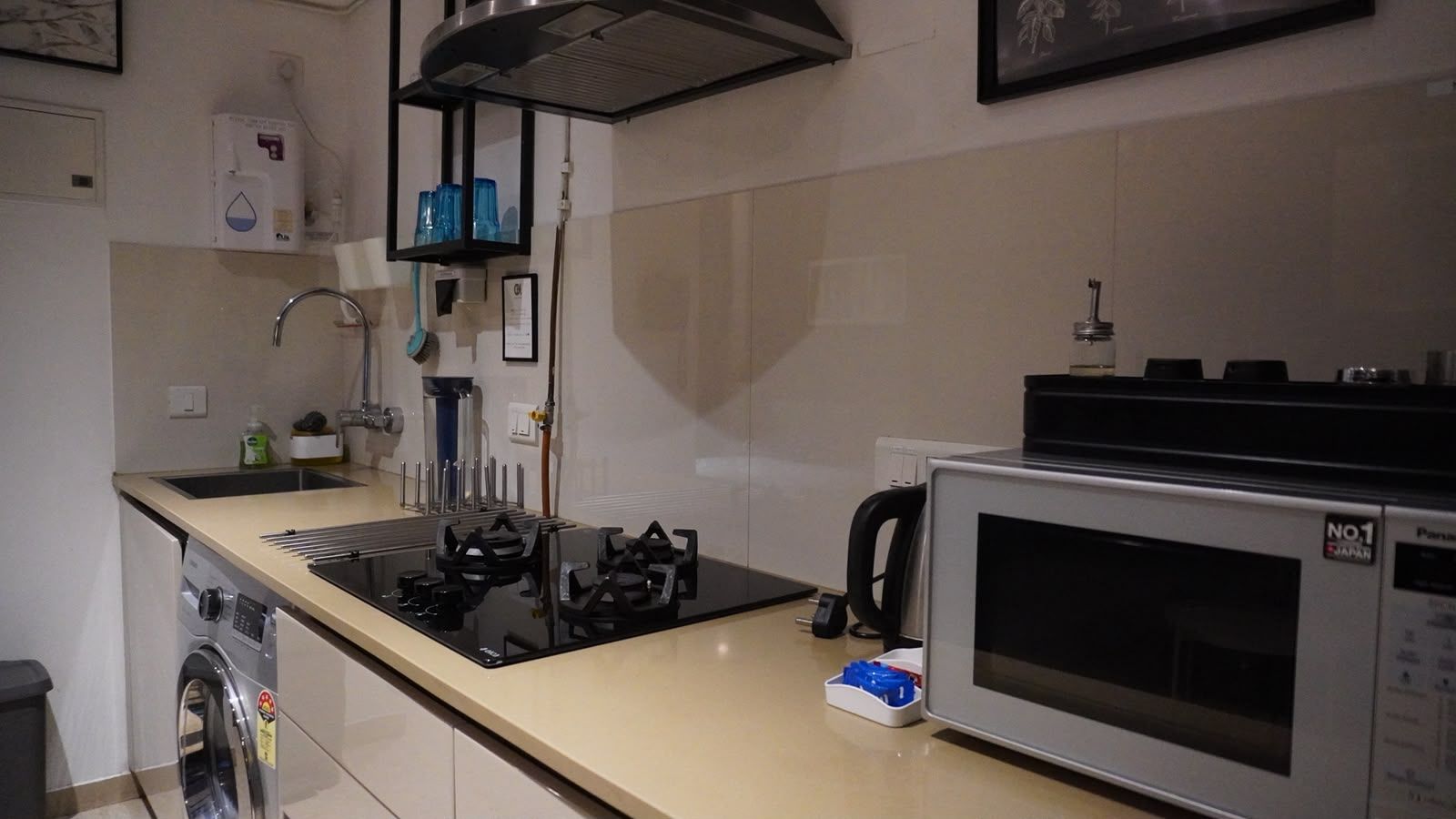 A kitchen with a built-in stove, a microwave, and a washing machine.