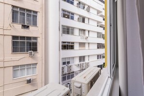 Un edificio de varios pisos con balcones y unidades de aire acondicionado.