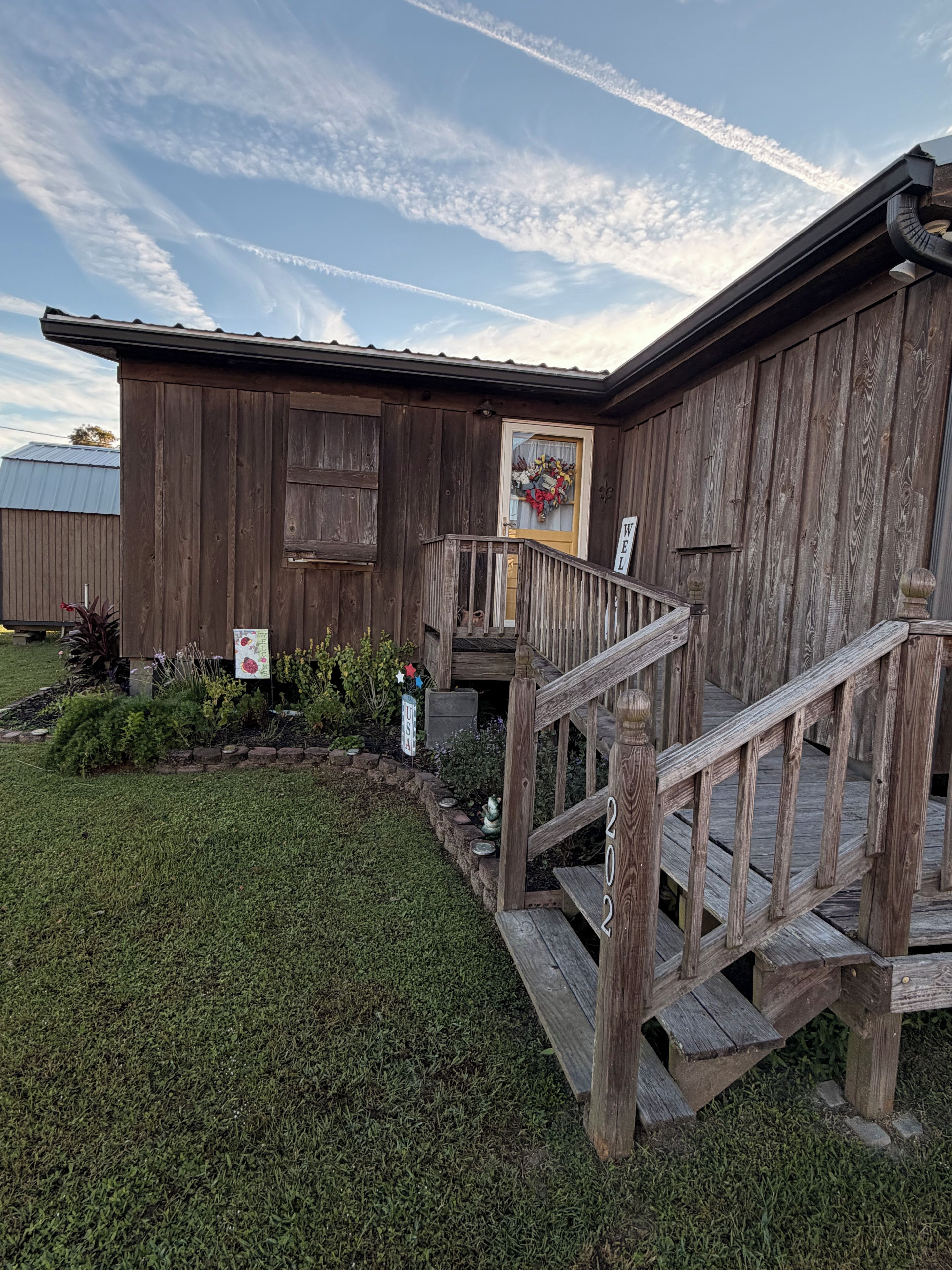A wooden building with a wooden staircase leading to a porch.