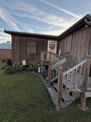 A wooden building with a wooden staircase leading to a porch. - The Fisherman’s Hideaway (Vacherie)