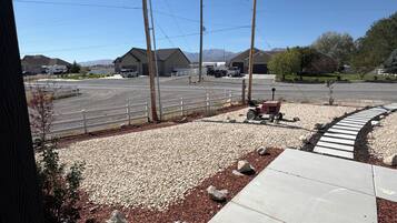 A parking lot with gravel and a paved walkway, utility poles, and a clear sky.