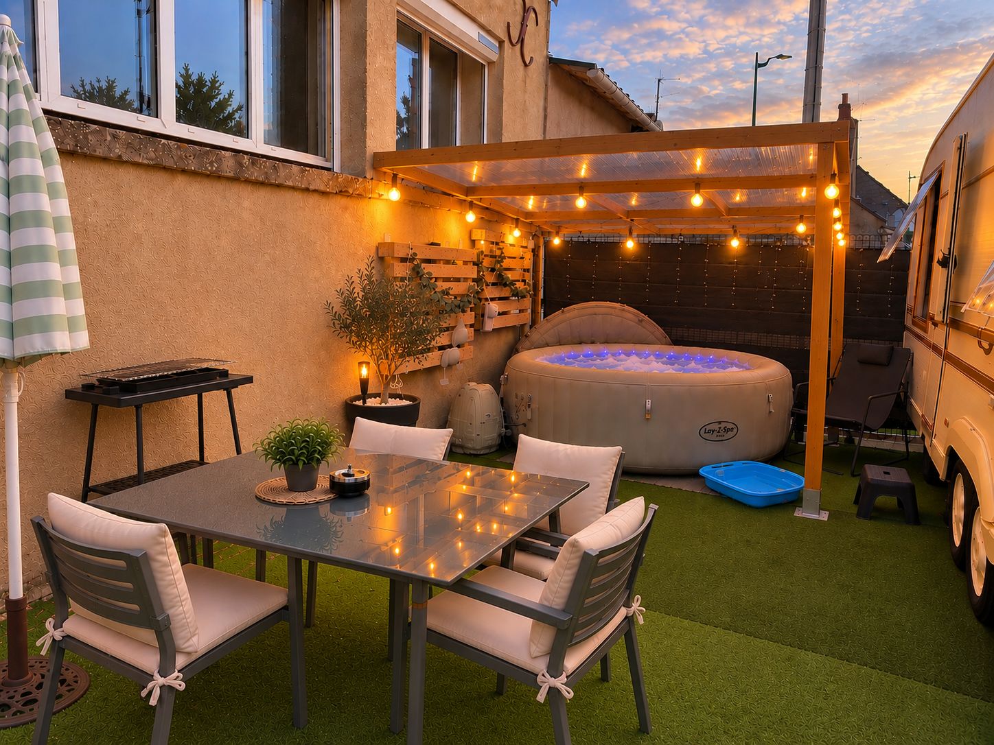 An outdoor patio with a table and chairs, a hot tub, and a pergola with string lights.
