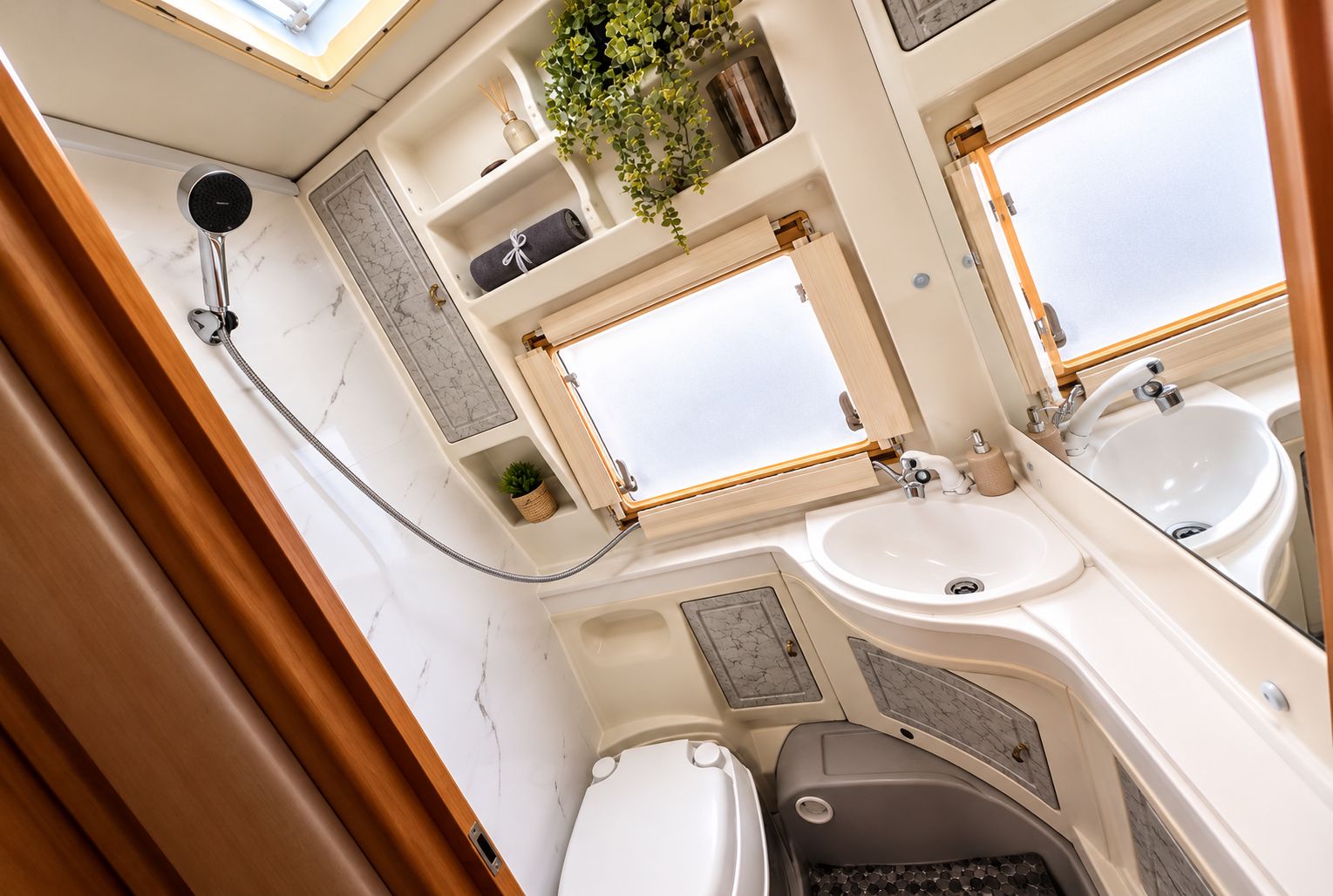 Une salle de bain compacte avec une douche, deux lavabos et des toilettes.