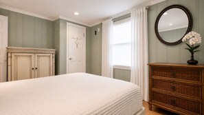 A bedroom with a bed, dresser, and a mirror. - Cozy 1-bedroom condo AC + Parking in Midtown Ocean City Near Convention Center (Ocean City)