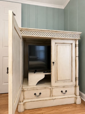 A piece of furniture with a television, drawers, and a cabinet door. - Cozy 1-bedroom condo AC + Parking in Midtown Ocean City Near Convention Center (Ocean City)