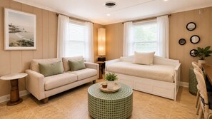 A living room with two sofas, a round coffee table, a side table, and a framed picture on the wall. - Cozy 1-bedroom condo AC + Parking in Midtown Ocean City Near Convention Center (Ocean City)
