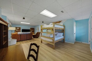 A room with bunk beds, a desk, a chair, a television, and a cabinet. - 5BR Smoky Mountain Escape, Hot Tub, Game Room, Sleeps 14,  10 min to Dollywood (Pigeon Forge)