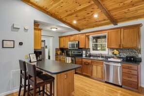 A kitchen with wooden cabinets, a stainless steel refrigerator, a microwave, and a sink. - 5BR Smoky Mountain Escape, Hot Tub, Game Room, Sleeps 14,  10 min to Dollywood (Pigeon Forge)
