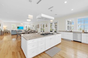 A spacious kitchen with a large island, white cabinetry, and a modern pendant light. - Bay Breeze Retreat | 6BR Group Getaway | Sleeps 15. (Panama City)