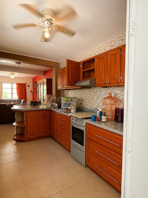 A kitchen with wooden cabinets, a built-in oven, and a countertop with various items.