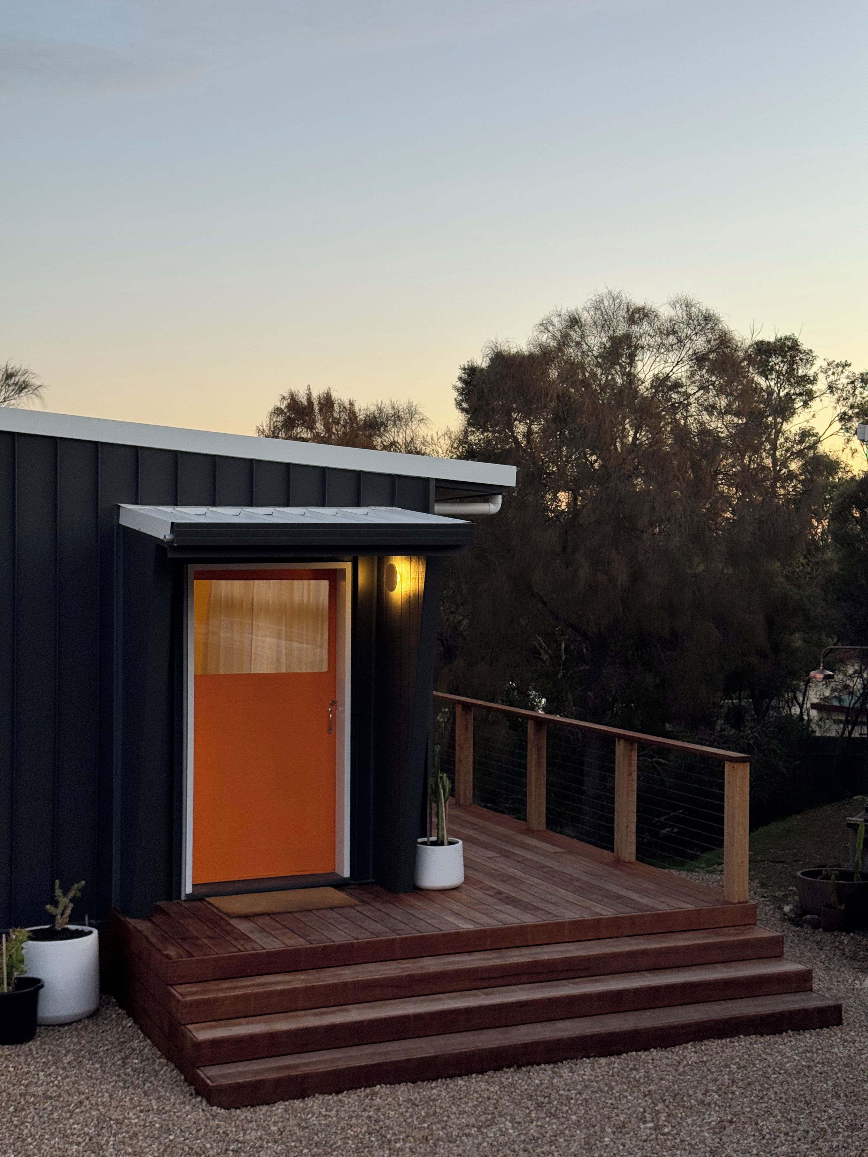A modern building with a wooden deck and a door.