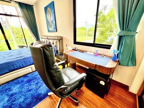 A room with a bed, a desk, a chair, a window with curtains, and a painting on the wall. - Blue Lion Villa Private Pool 3BR Kamala (Kamala)