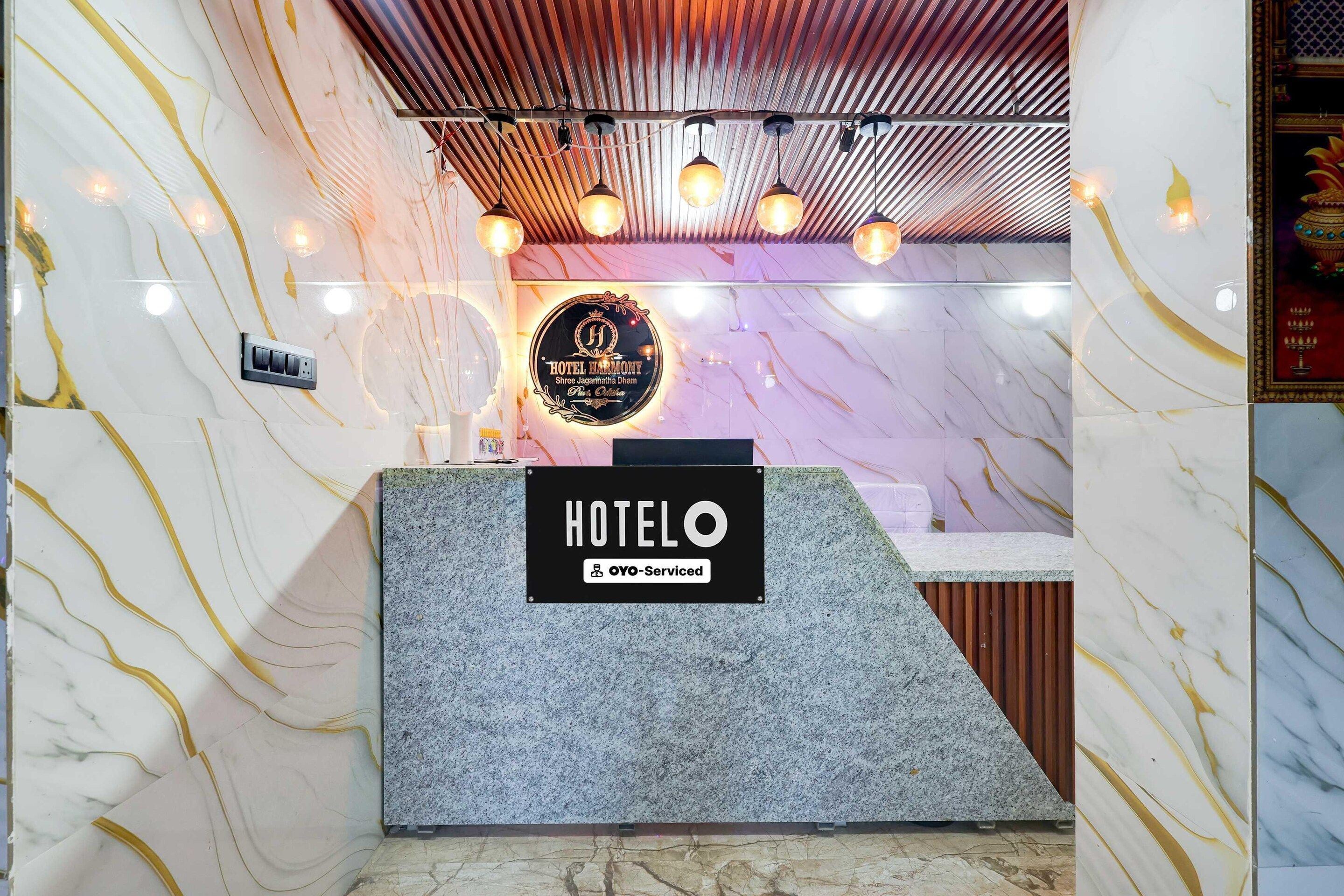 Un comptoir d’accueil avec un mur en marbre et une enseigne indiquant que l’établissement est géré par OYO.