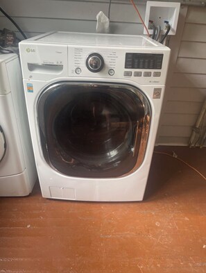 A front-loading LG steam cycle washing machine with a control panel and a detachable front. - Cozy 2-bedroom bungalow near Mercer in Macon with AC (Macon)