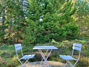 A wooden deck with a white table and two white chairs. - 7 Person Holiday Home in Graddo (Gräddö)
