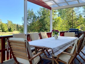 An outdoor patio with a table set for dining, surrounded by wooden chairs. - 7 Person Holiday Home in Graddo (Gräddö)