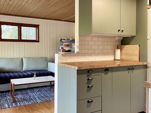 A compact living space with a kitchenette, a sofa, and a small table. - 7 Person Holiday Home in Graddo (Gräddö)