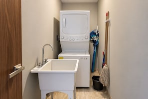 A compact laundry room with a washing machine, a sink, and a mop. - 2 BR Penthouse, Downtown area, Ocean views (Cabo San Lucas)