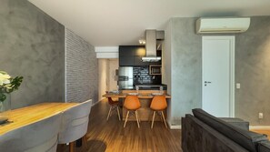 A modern kitchen with a dining area, including a wooden table and chairs, and a built-in oven. - Habitarte | 2 suites with views and leisure facilities high up (São Paulo)
