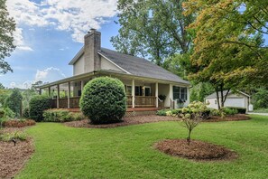 A single-story house with a covered porch, a chimney, and a well-maintained lawn. - House on the Hill near Blue Ridge Pkwy & Downtown (Asheville)