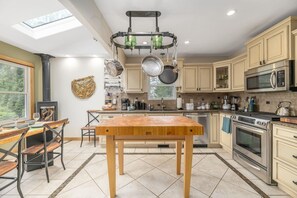 A modern kitchen with a central island, stainless steel appliances, and a skylight. - House on the Hill near Blue Ridge Pkwy & Downtown (Asheville)