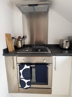 A compact kitchen with a gas stove, a toaster, and a kettle. - Stylish 2 bedroom apartment, just 15 minutes walk from Uxbridge town centre. (Uxbridge)