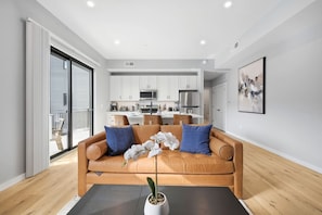 Un salon moderne avec un canapé en cuir, une table basse et une plante en pot.