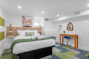 A modern bedroom with a bed, bedside table, and a desk with a chair. - Modern Palm Springs Retreat| 4 BR 4 Bath| Central (Pittsburgh)