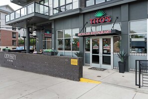 A TITO'S Mexican restaurant with a brick facade, large windows, and outdoor seating. - The Rhiannon | Pool, Parking & Private Balcony (Nashville)