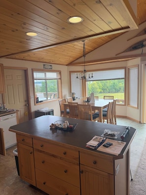 A kitchen with a wooden island, dining table, chairs, and a chandelier. - Star Lake Escape, Dent MN (Dent)