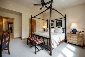 A four-poster bed with a wooden canopy, a bench, a dresser with drawers, and a ceiling fan. - AN122 | Newly Listed | Winter Shuttle | Ski In/Out (Steamboat Springs)
