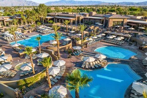 Ein Resort mit mehreren Schwimmbecken, Liegestühlen und Sonnenschirmen.