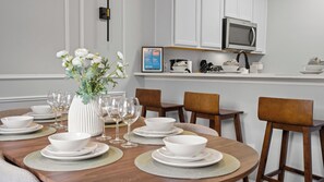 A dining area with a round table set for six, surrounded by wooden chairs. - Super Mario & Mickey Kids Rooms, Near Disney (Kissimmee)