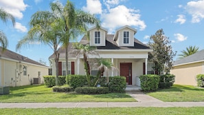 A two-story residential house with a front porch, a satellite dish, and a mailbox. - 4BR Near Disney at Trafalgar Village (Kissimmee)