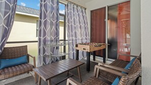 A room with a foosball table, a glassware rack, and wicker furniture. - 4BR Near Disney at Trafalgar Village (Kissimmee)