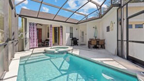 Ein Schwimmbad mit Whirlpool, einer überdachten Terrasse und einem Esstisch mit Stühlen.