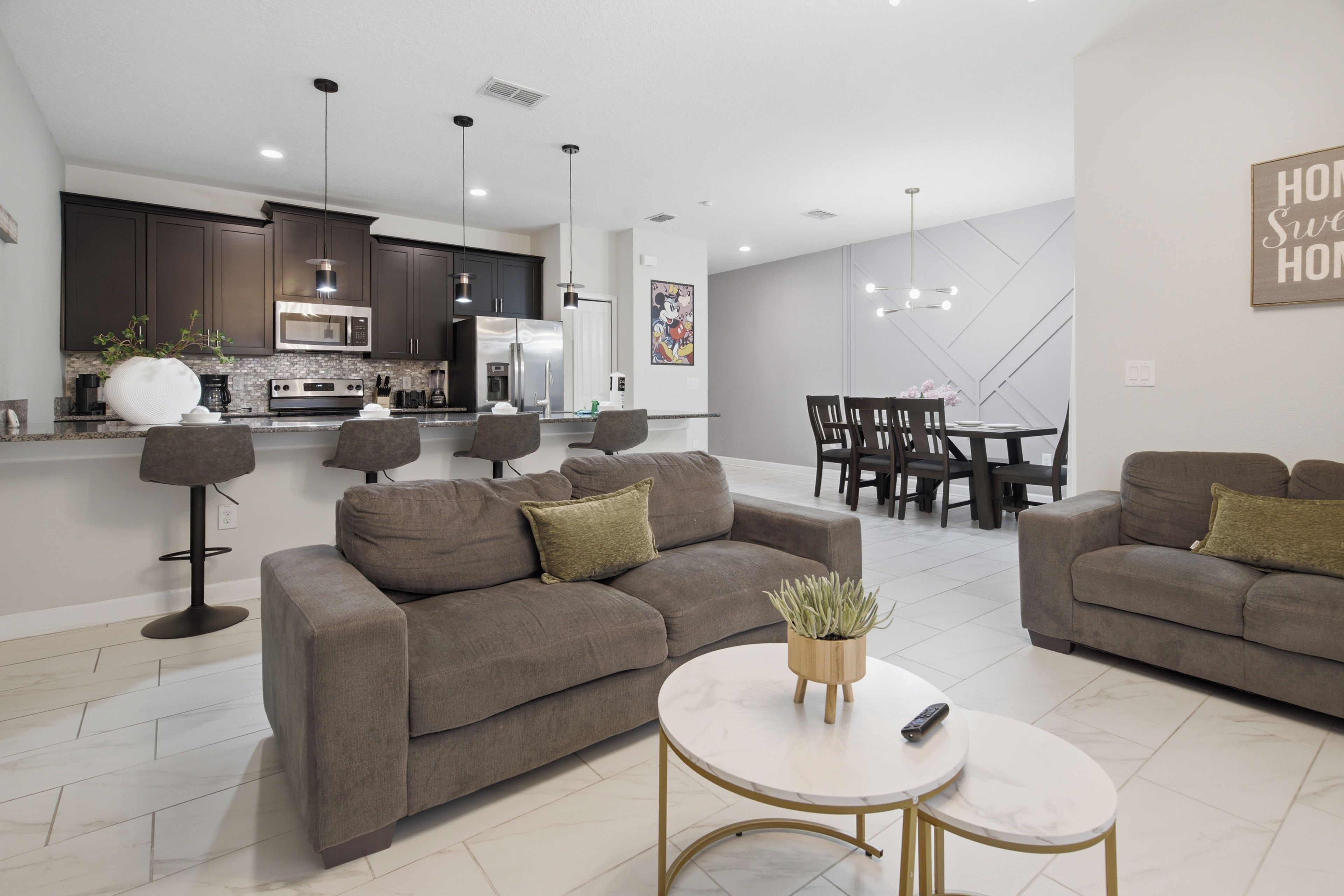 Ein modernes Wohnzimmer mit einer Couch, einem Couchtisch und einem Essbereich mit Stühlen und Tisch.