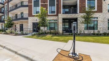 A modern building with a brick facade, a parking area, and a charging station.