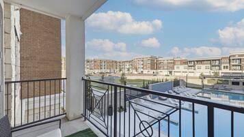 Ein Balkon mit Blick auf einen Swimmingpool und Apartmenthäuser im Hintergrund.