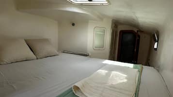 Un dormitorio pequeño con una cama individual, una ventana y un tragaluz.