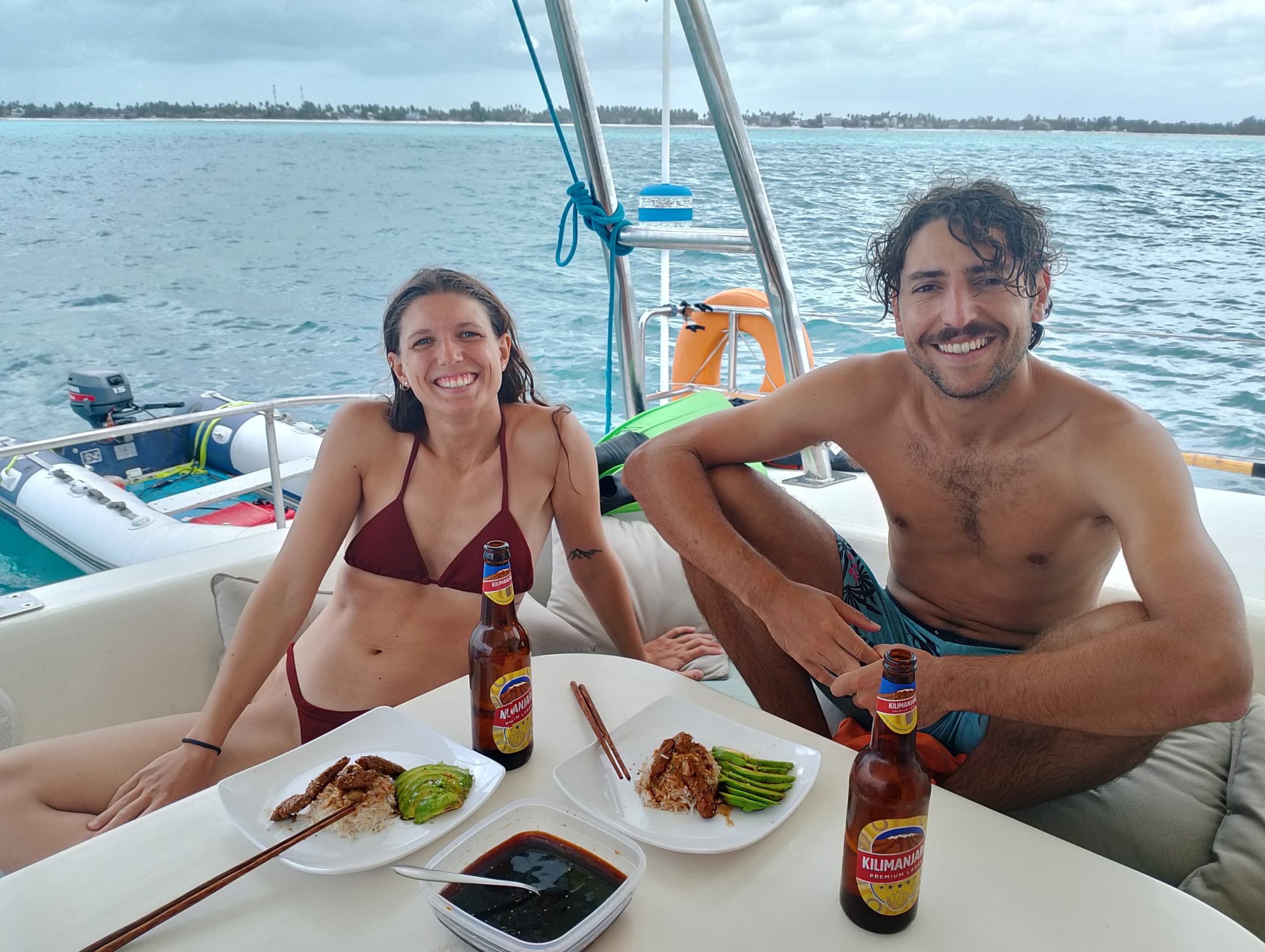 Un bote con dos personas sentadas en una mesa, con comida y bebidas.