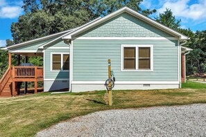 A two-story house with a covered porch and a gravel driveway. - Charming 3-bedroom lakehouse in Hartwell with plenty of outdoor living space (Hartwell)