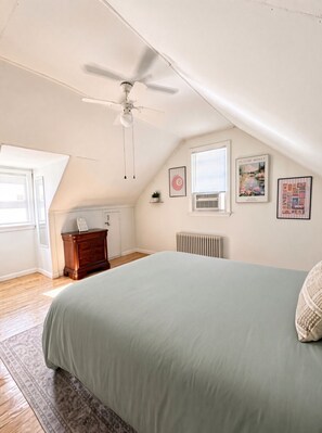 A bedroom with a bed, a ceiling fan, a radiator, and a window. - Charming 3-bedroom 2- bathroom house with AC in South Plainfield (South Plainfield)
